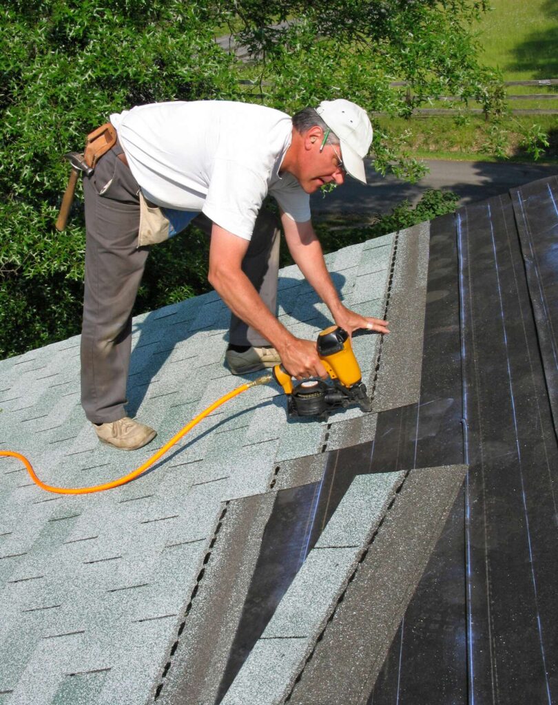 Man installing roof shingles