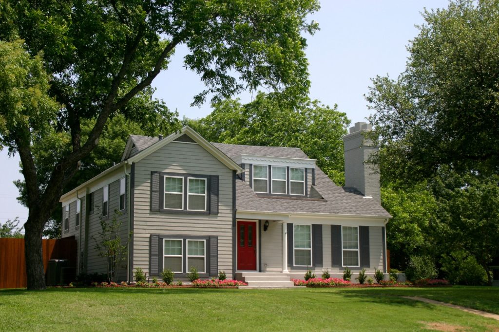 Two-story gray vinyl siding home in a Cleveland neighborhood surrounded by trees