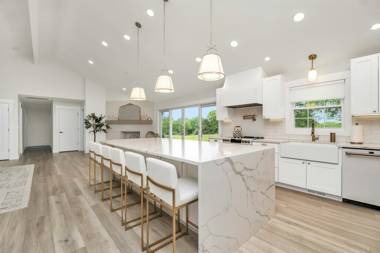 A large modern kitchen with a marble island and white cabinets