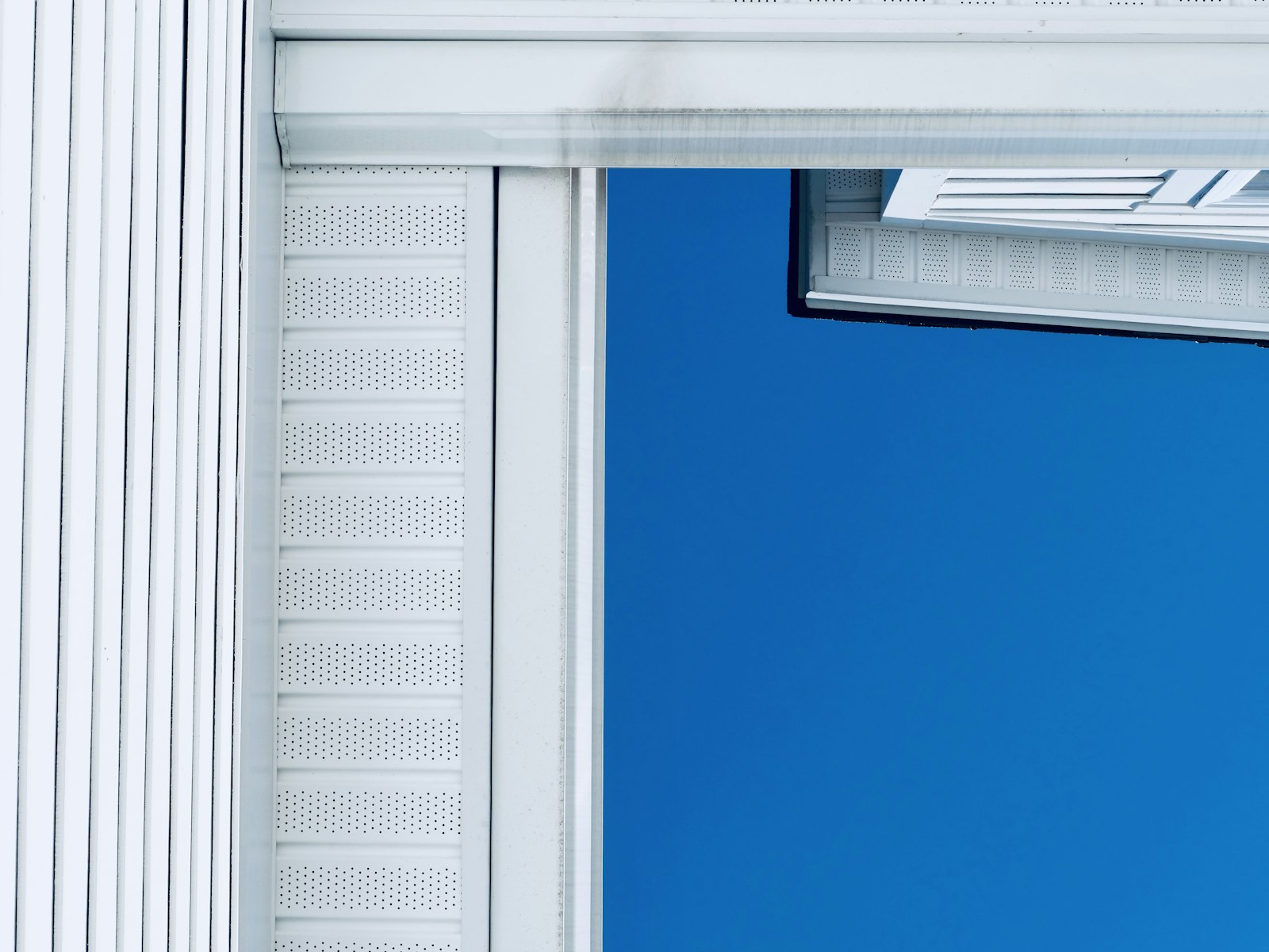 White vinyl siding on a home against a bright blue sky